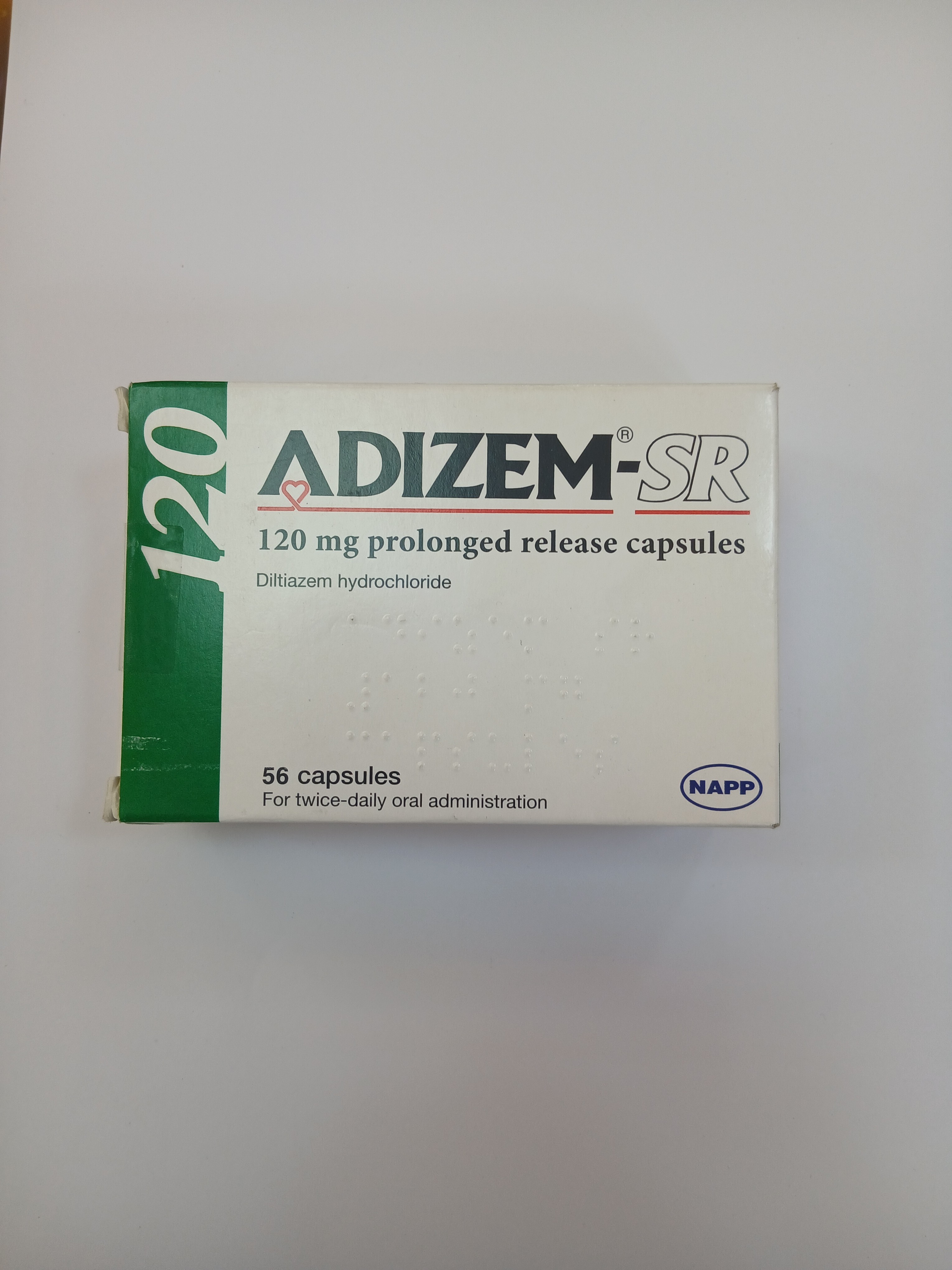 A white and green cardboard box packaging displays text indicating it contains 56 prolonged-release capsules in a blister pack.