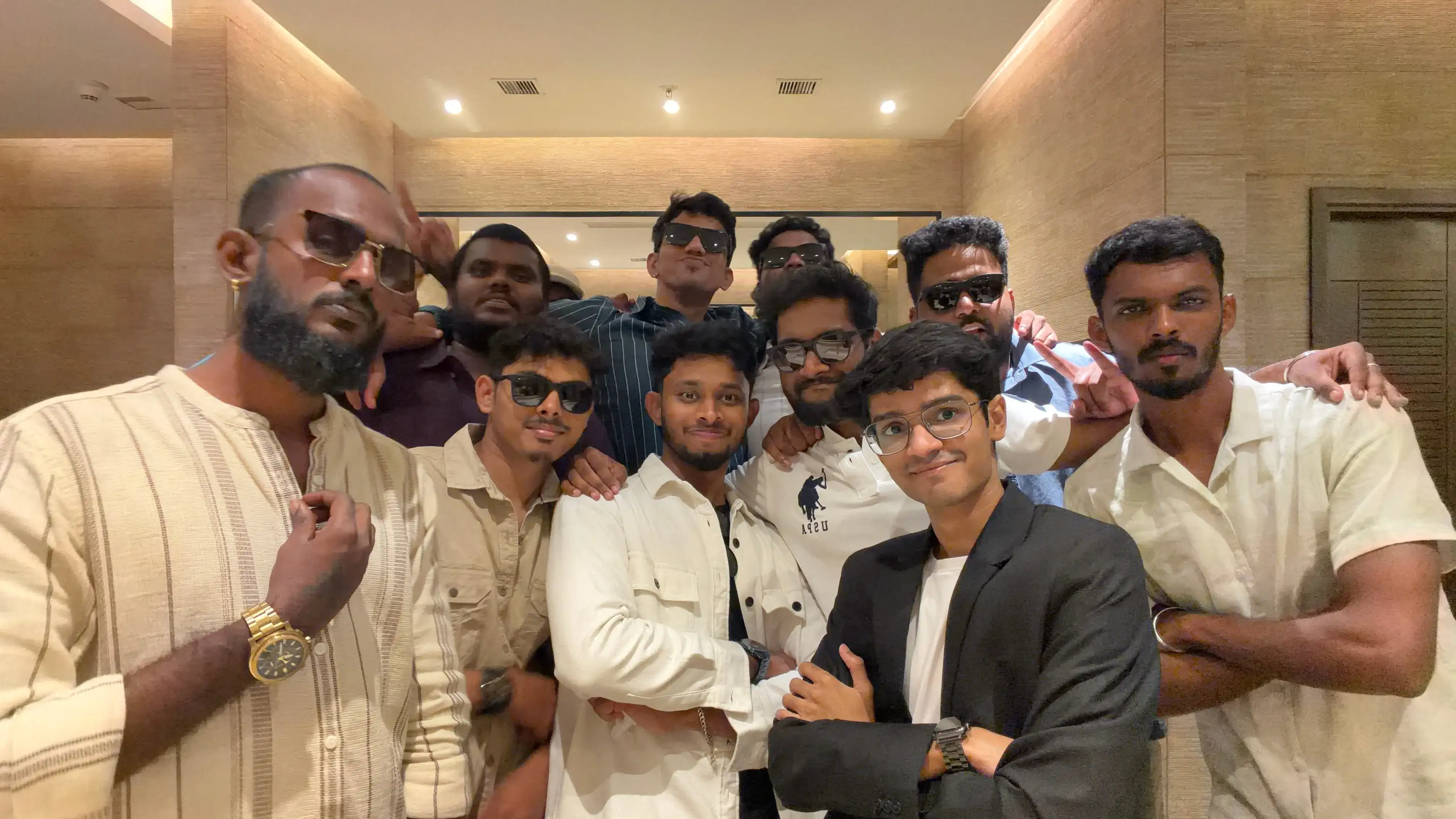 Group selfie of Maayasthra team members dressed in semi-formal attire at a social gathering.