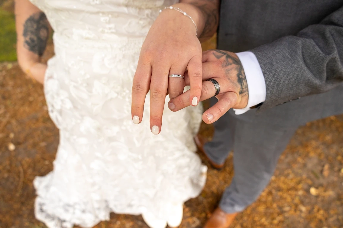 Close-up of Hannah and Shawn showing their wedding rings during their wedding day