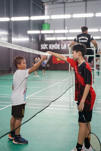 two young boys are playing tennis on a court