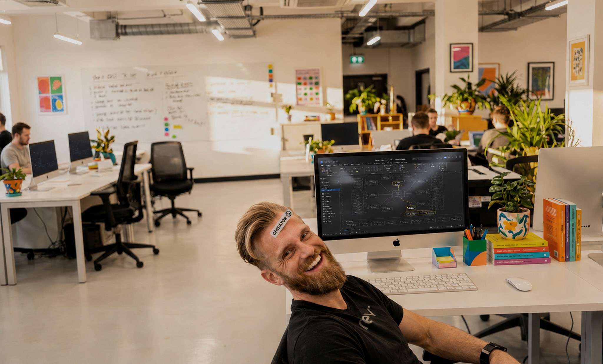 Bright open-plan co-working space filled with lush plants, wooden desks, and a person working at a computer by floor-to-ceiling windows