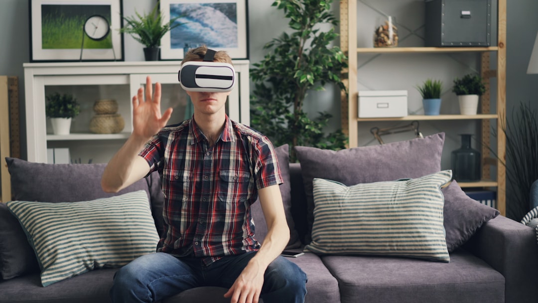a man sitting on a couch wearing a virtual headset