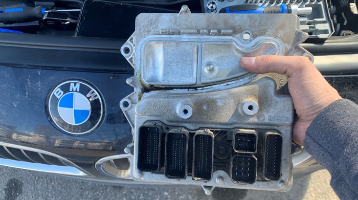 BMW engine control unit (ECU) removed from the vehicle for EEPROM car key programming and immobilizer data work.