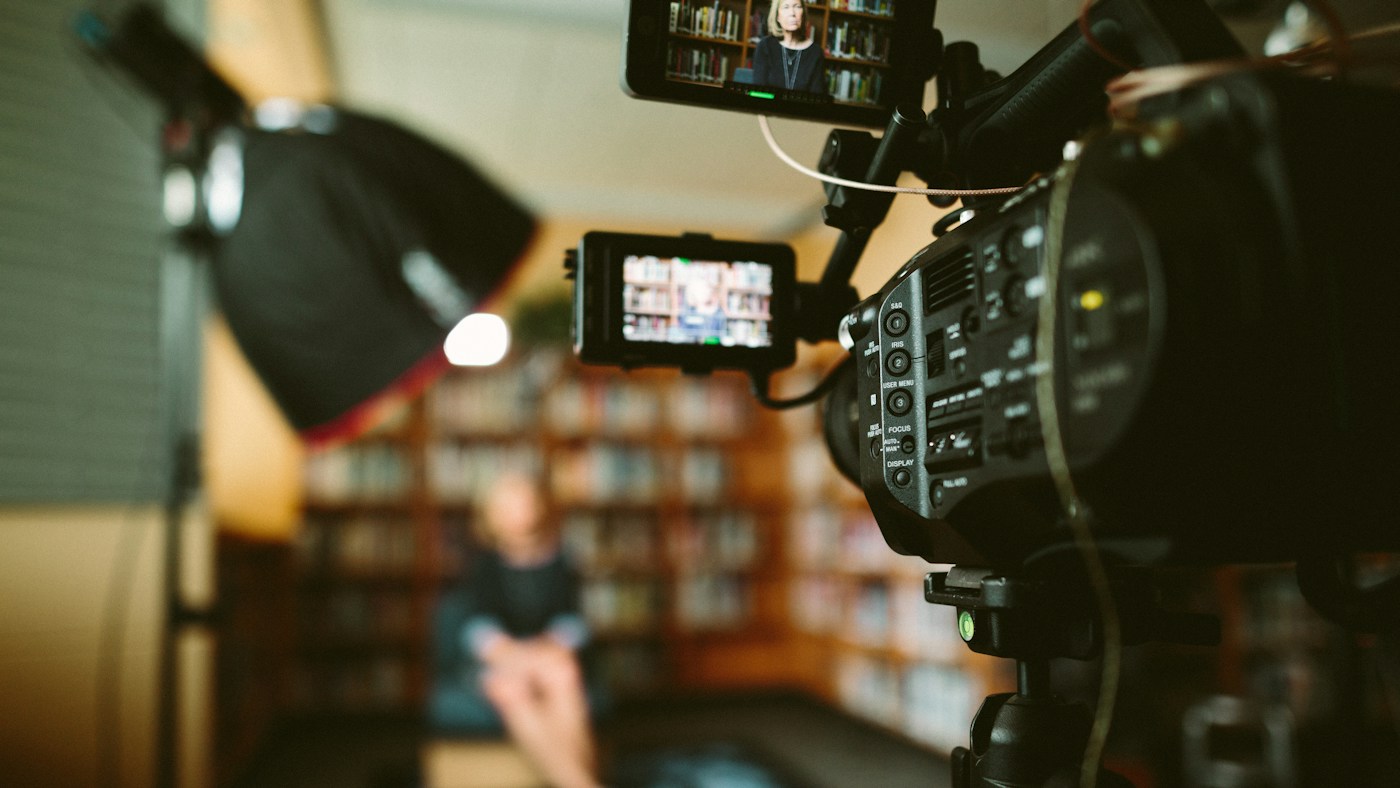 Interview subject seated in a warm interior prepared for a filmed conversation