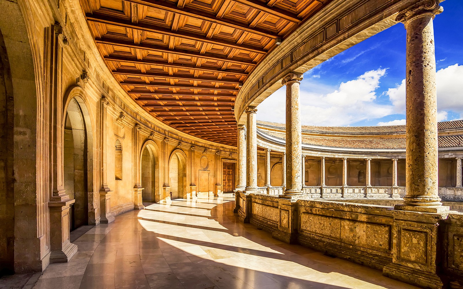 格拉纳达，西班牙的阿尔罕布拉宫内，圆形庭院环绕着石柱和拱门。