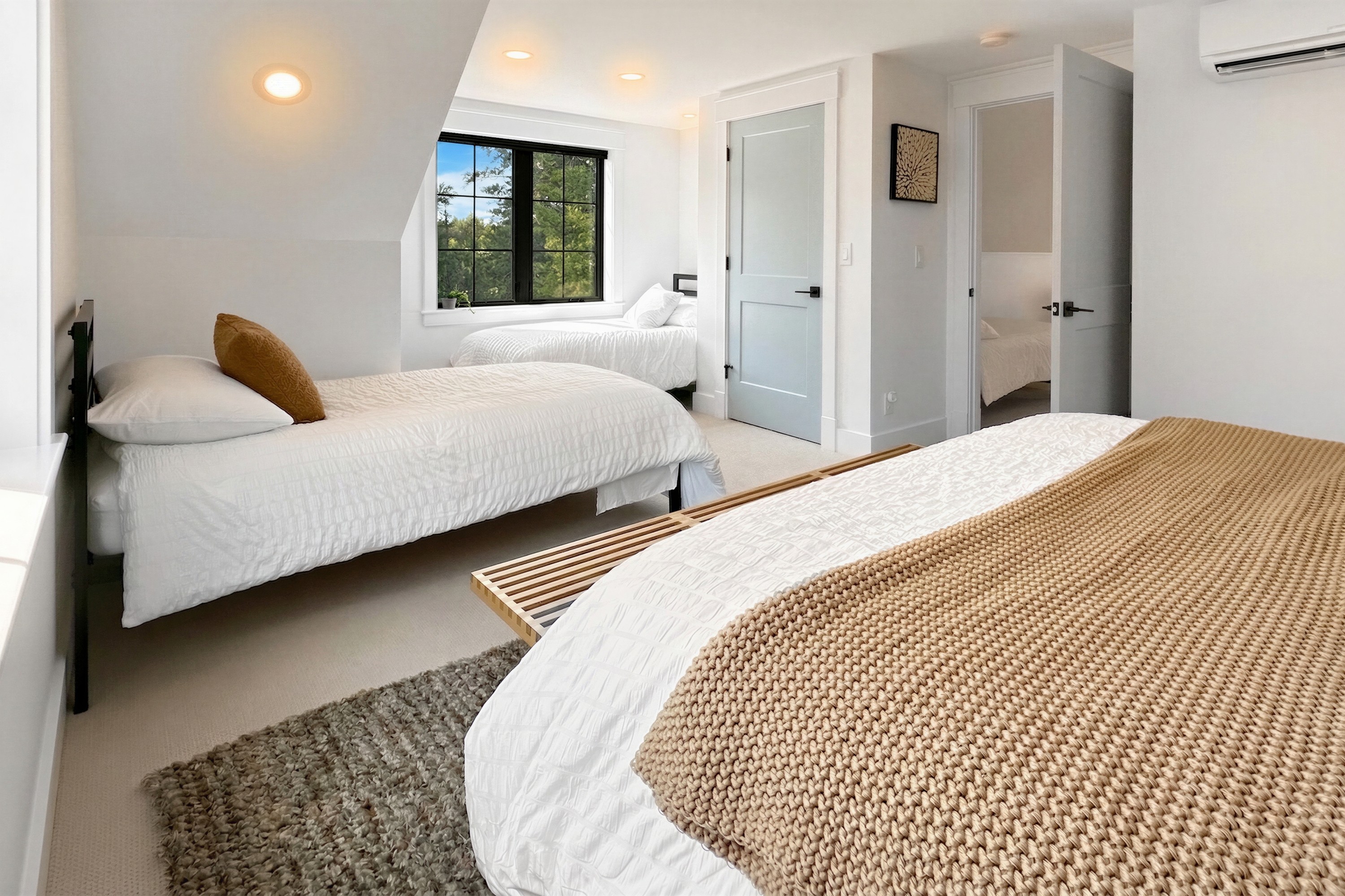 Bedroom with a gray upholstered headboard and forest views