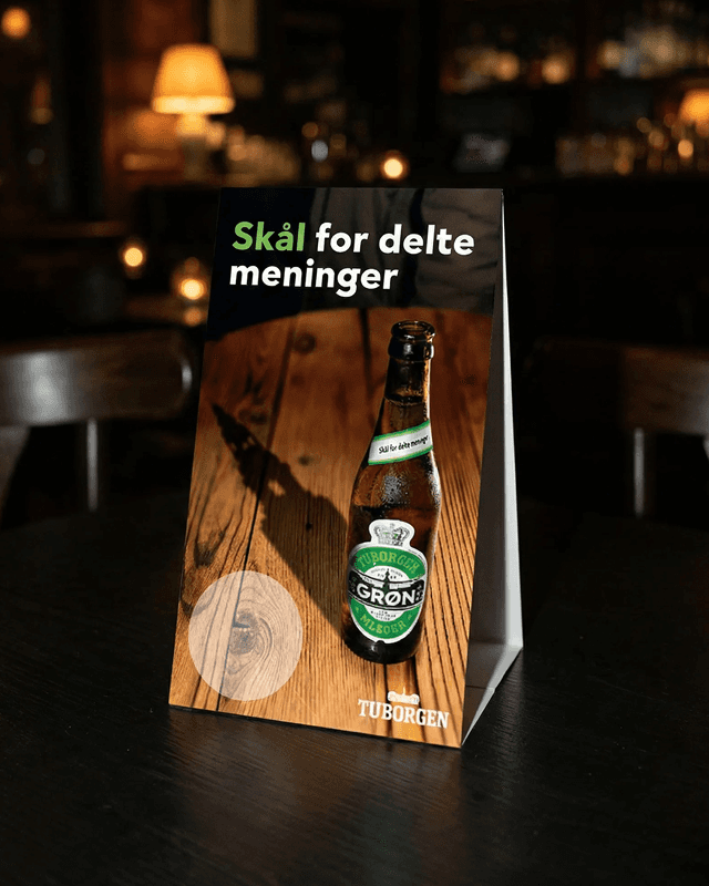 Tuborgen table display — bottle with POS stand reading Skål for delte meninger, packaging and art direction