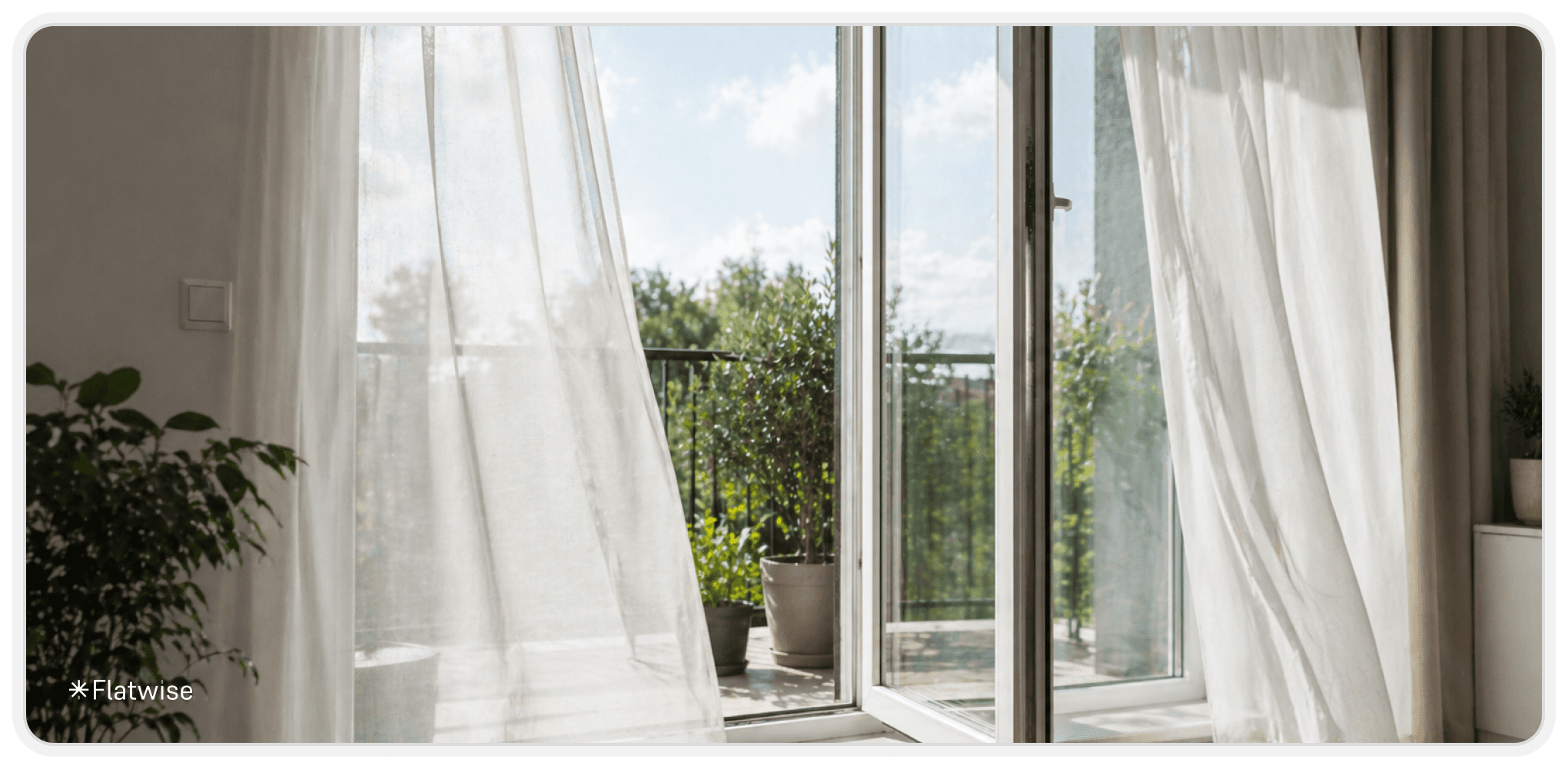 Heller Wohnraum mit geöffneter Balkon- oder Terrassentür, durch die eine leichte Brise weht und die weißen Vorhänge sanft in Bewegung versetzt, mit Blick ins Grüne.