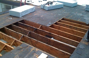 Modern bathroom featuring a walk-in shower, wooden vanity, round mirror, and elegant marble tiles.