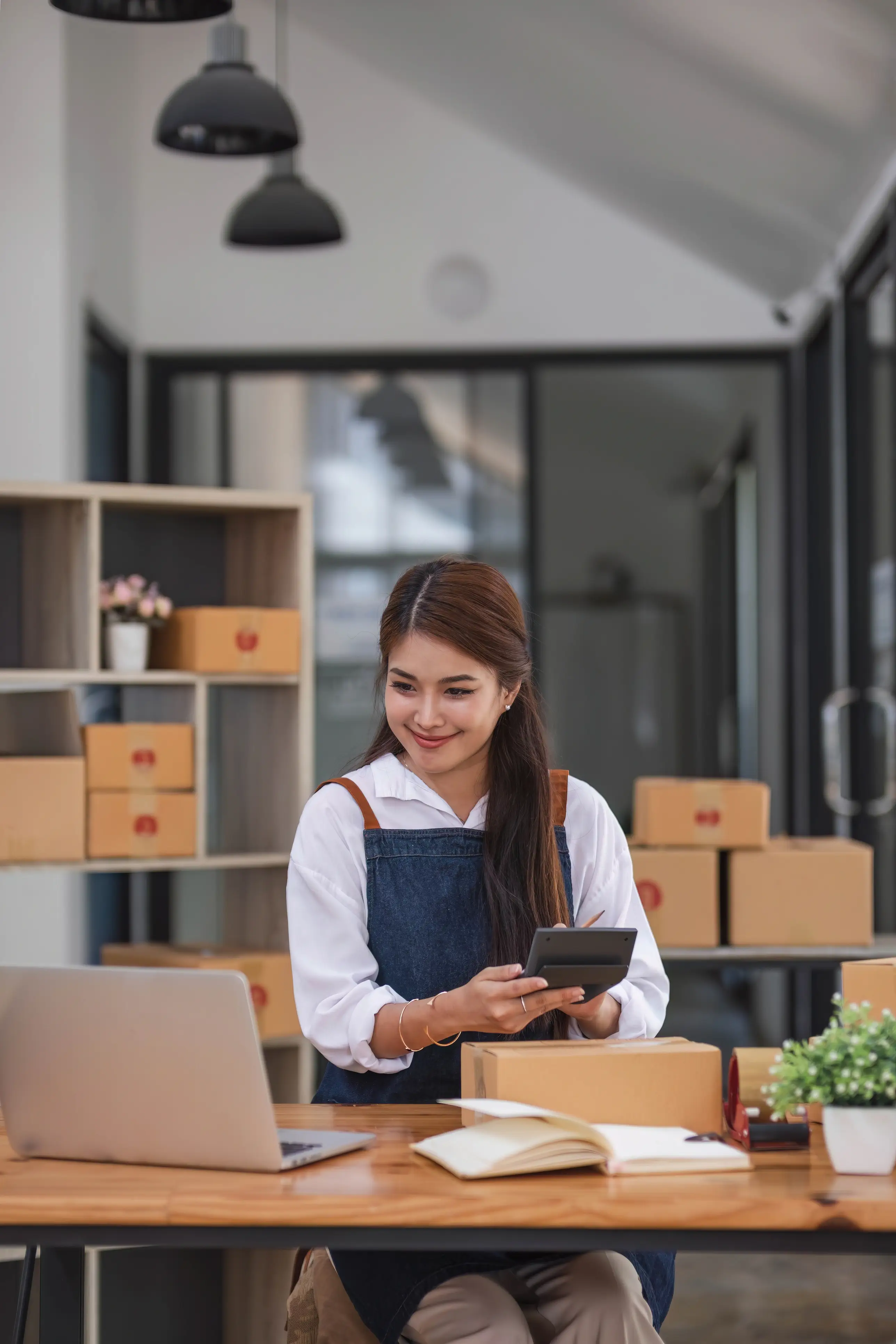 Small business owner sitting on a desk viewing a computer