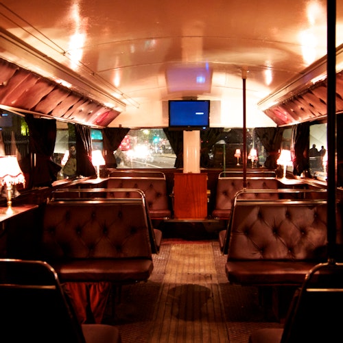 复古公交车的内部装饰有簇绒皮革座位隔间,小台灯和安装在前墙的电视。