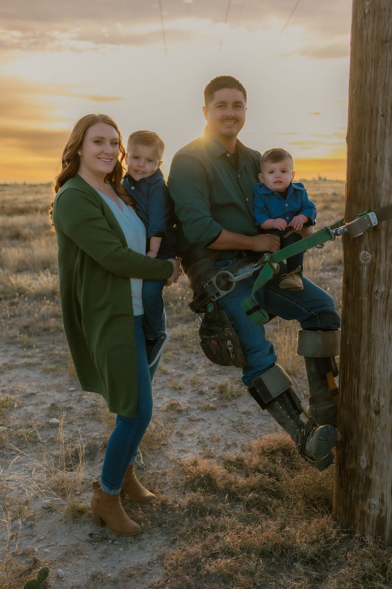 A family of four posing for a picture on a beautiful day.