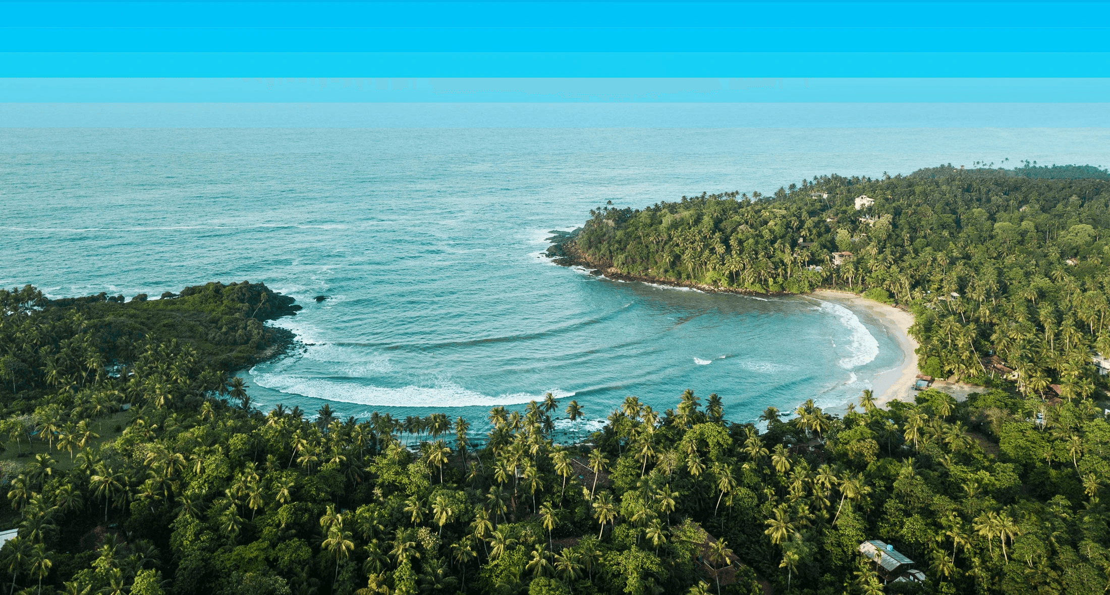 Scenic bay in Sri Lanka with turquoise water, palm-fringed shoreline, and distant reef