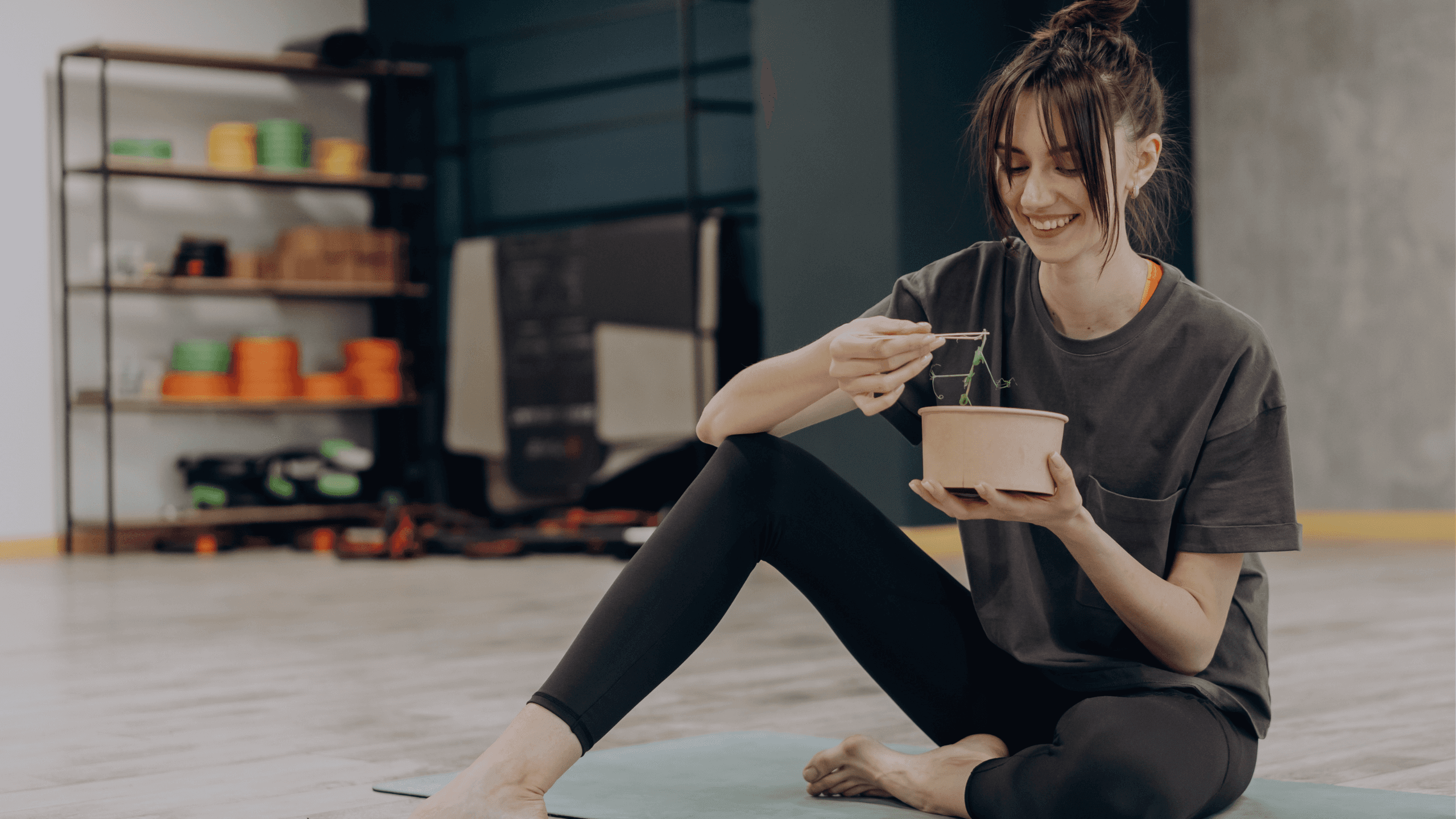 A woman smiling and eating food