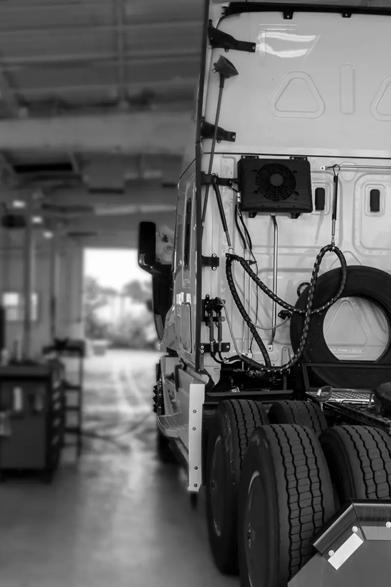 Back of a semi-truck in an indoor maintenance facility illustrating physical damage coverage by Reliable Transportation Association