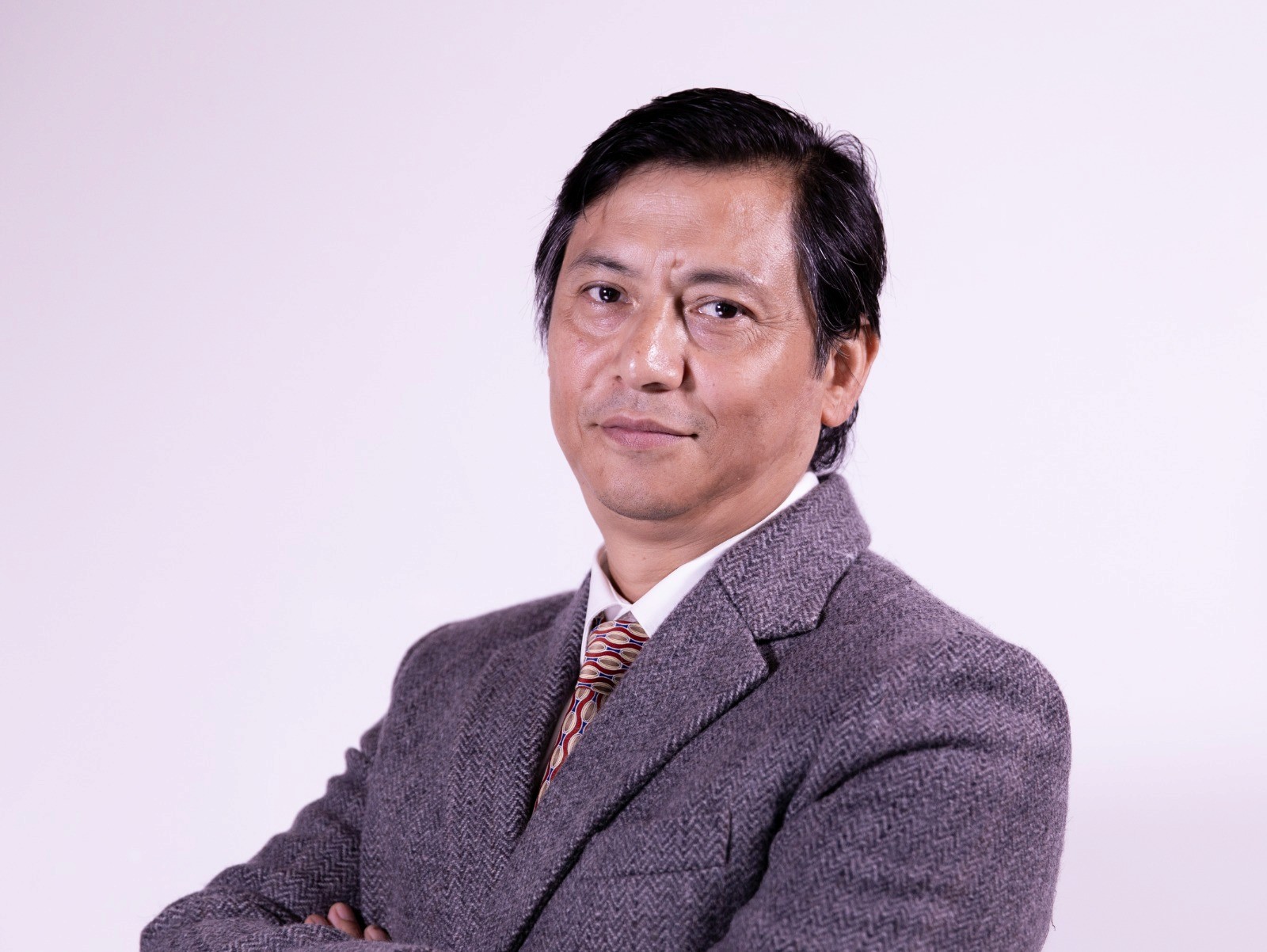 man in black suit jacket holding white ceramic mug