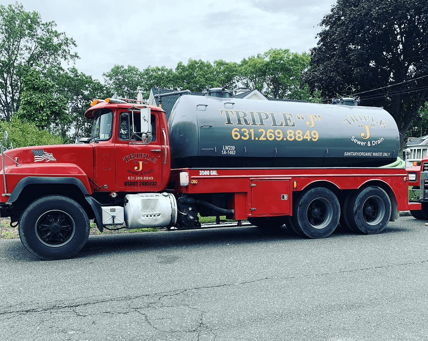 Triple “J” red cesspool pump truck on a Long Island street