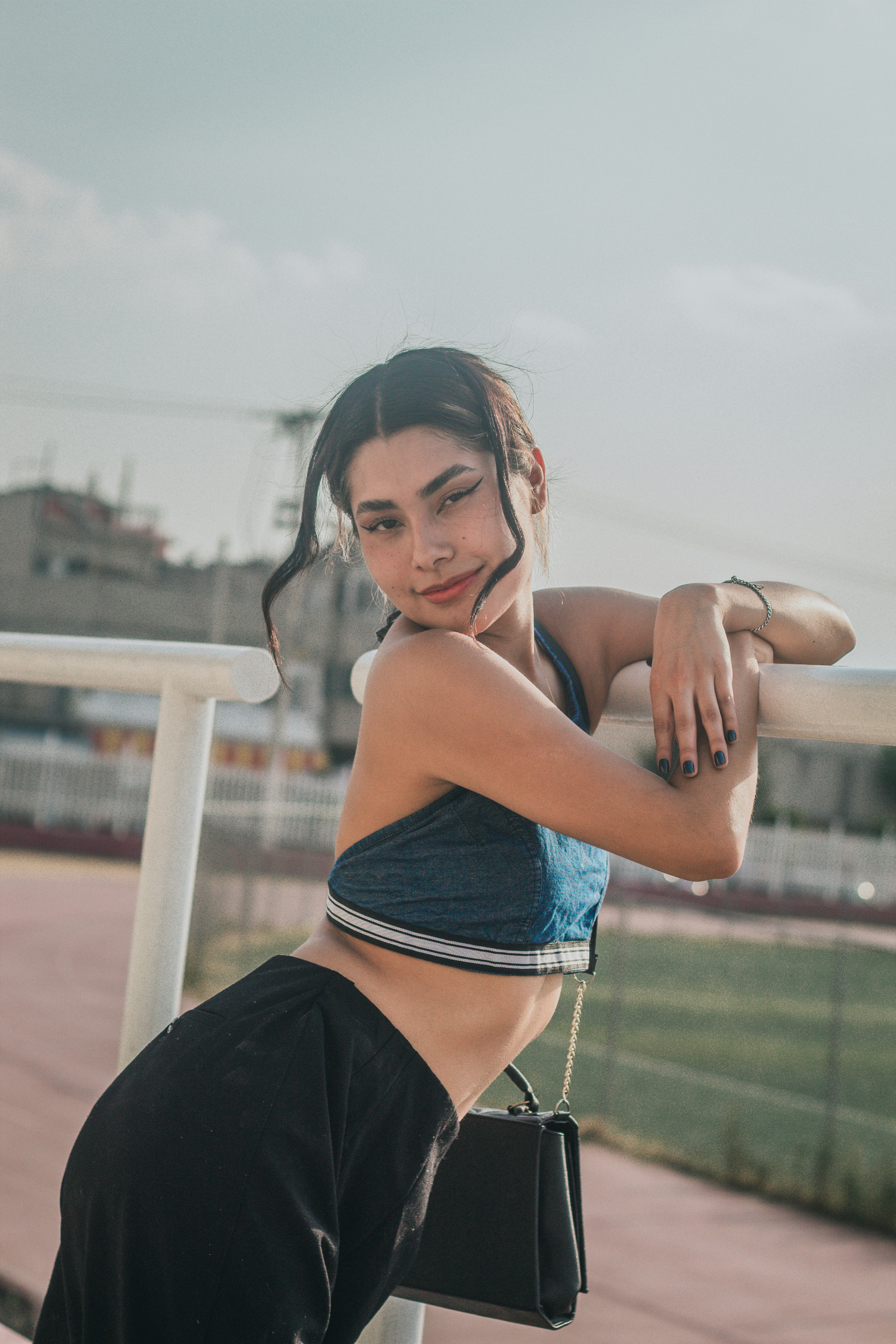 a woman in a sports bra top leaning on a rail