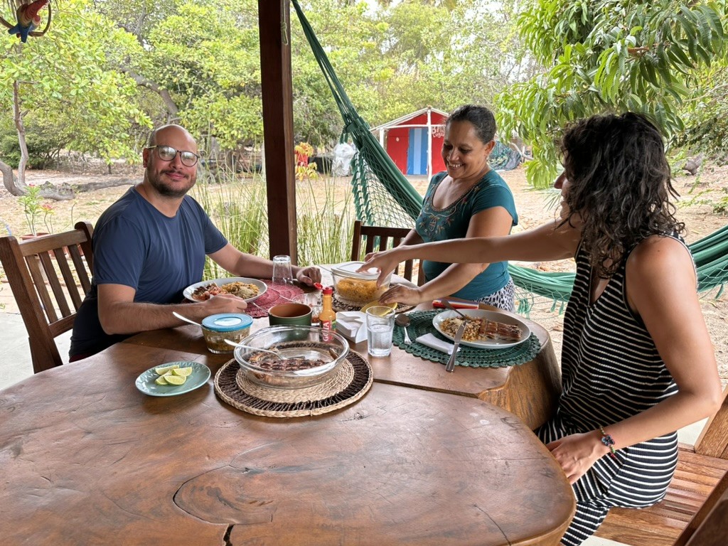 Visitantes de São Paulo saboreiam pratos preparados por Patrícia, pescadora local. 