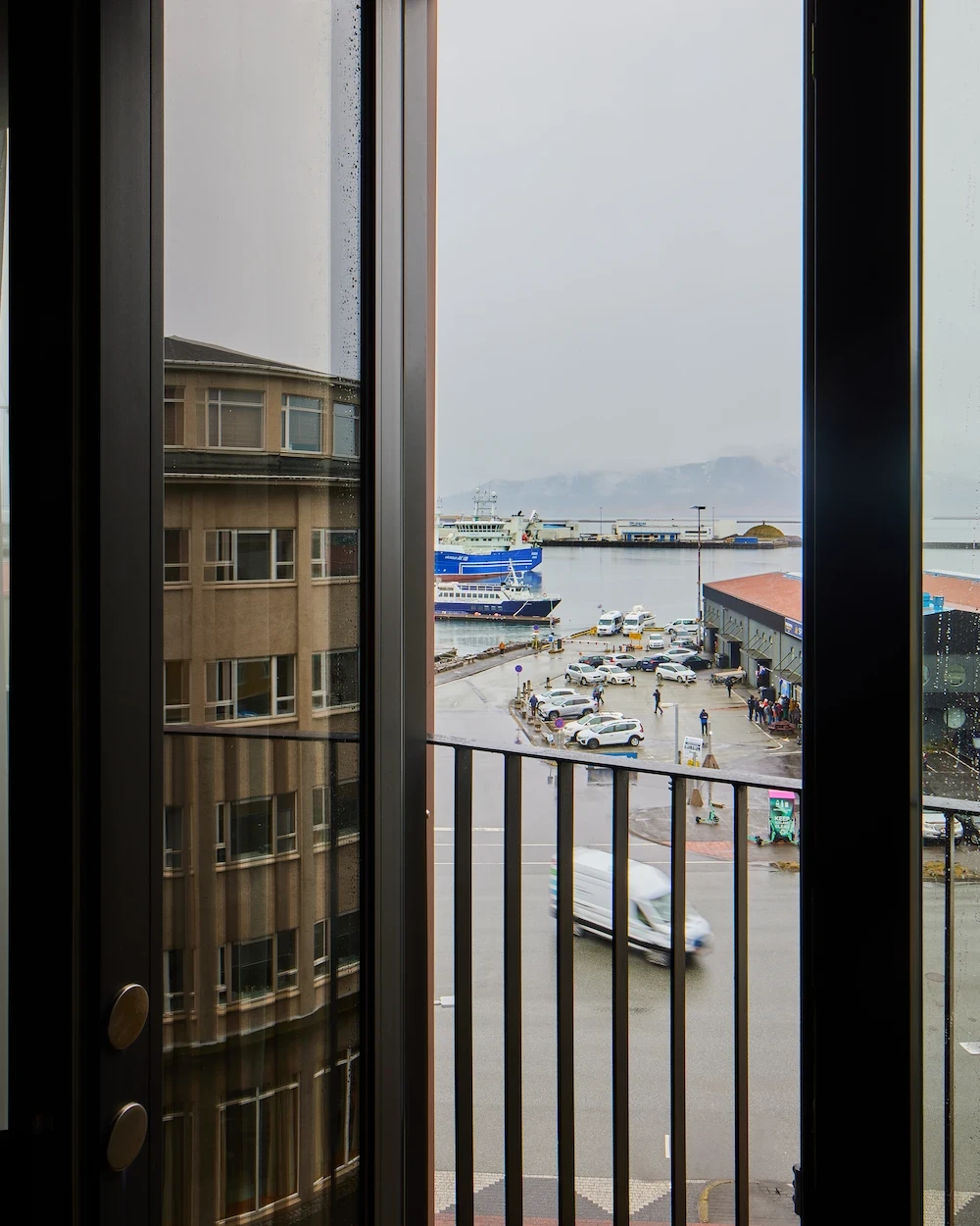 Harbour view through the Junior Suite window and balcony railing.