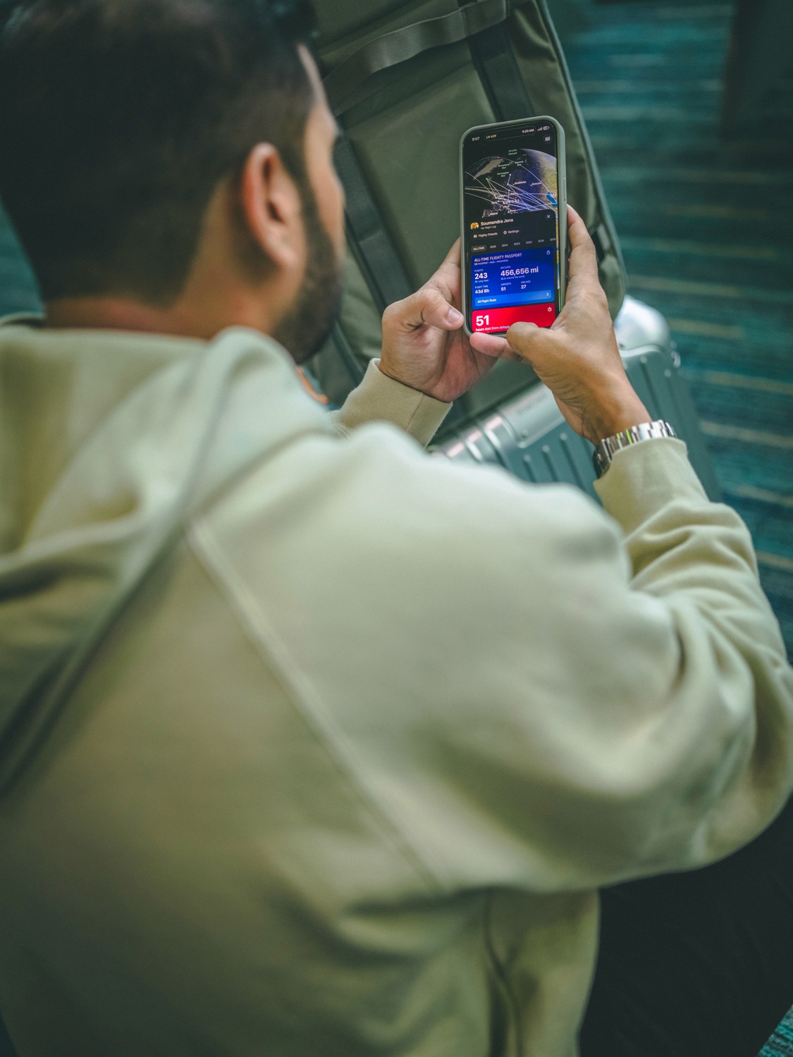 Person in a blue hoodie looking upwards into a dramatic blue light.