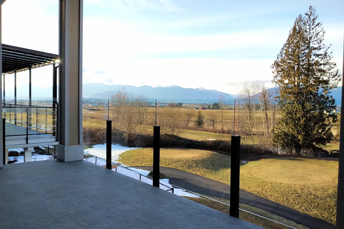 Semi-frameless glass deck railing with black posts.