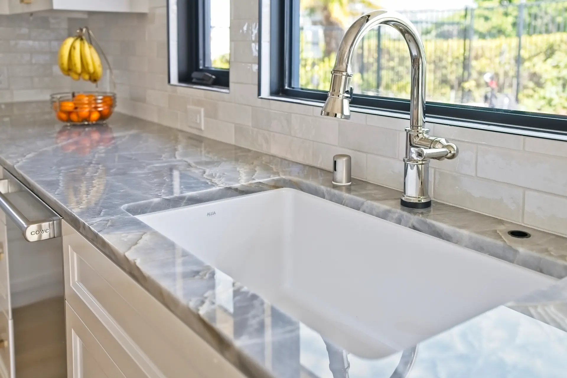Close-up of the modern kitchen sink, emphasizing the sleek design and functionality essential for a sophisticated cooking space in the Dana Point Full Remodel. Photo by Todd Huge.