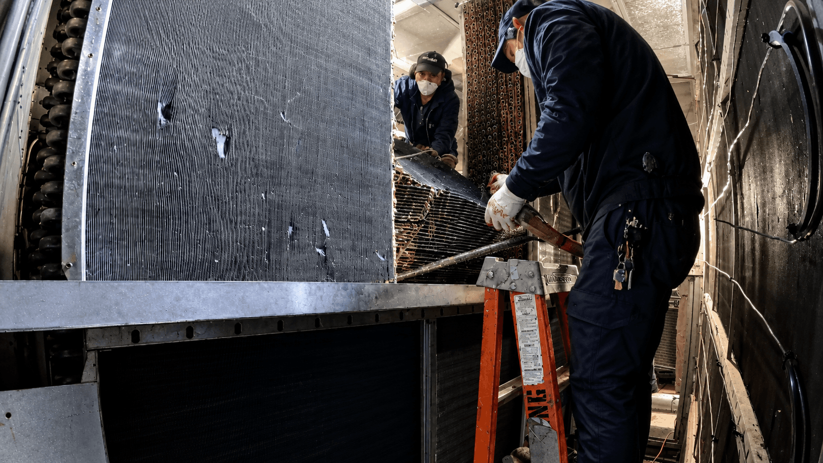 GRR Cooling Experts technicians working around a damaged chilled water coil section during a hospital HVAC coil replacement project in New York City.