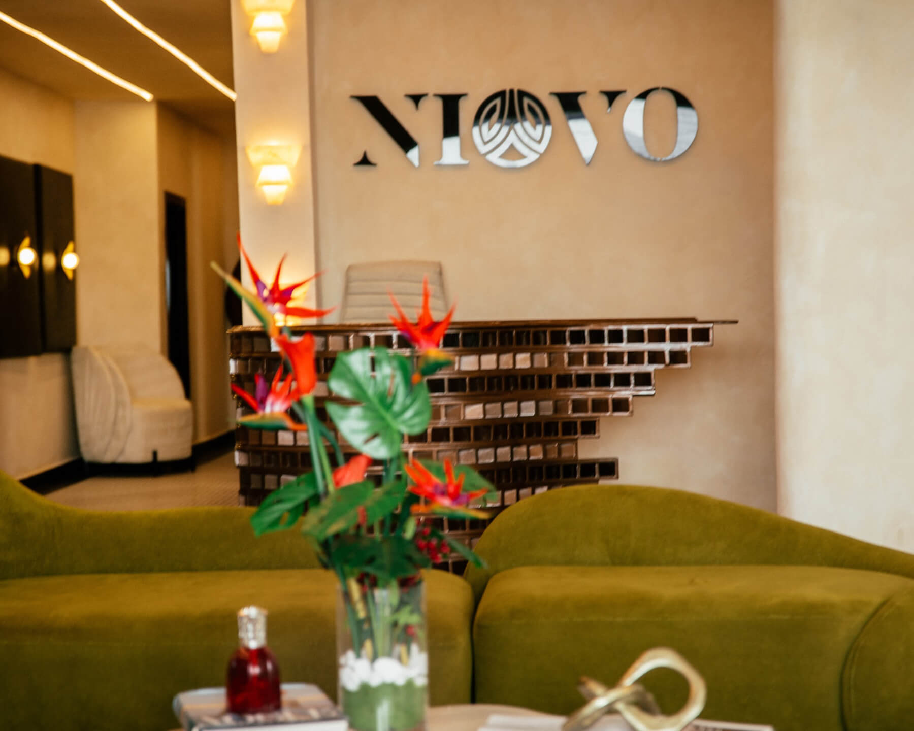 A green butterfly rests on a flower.