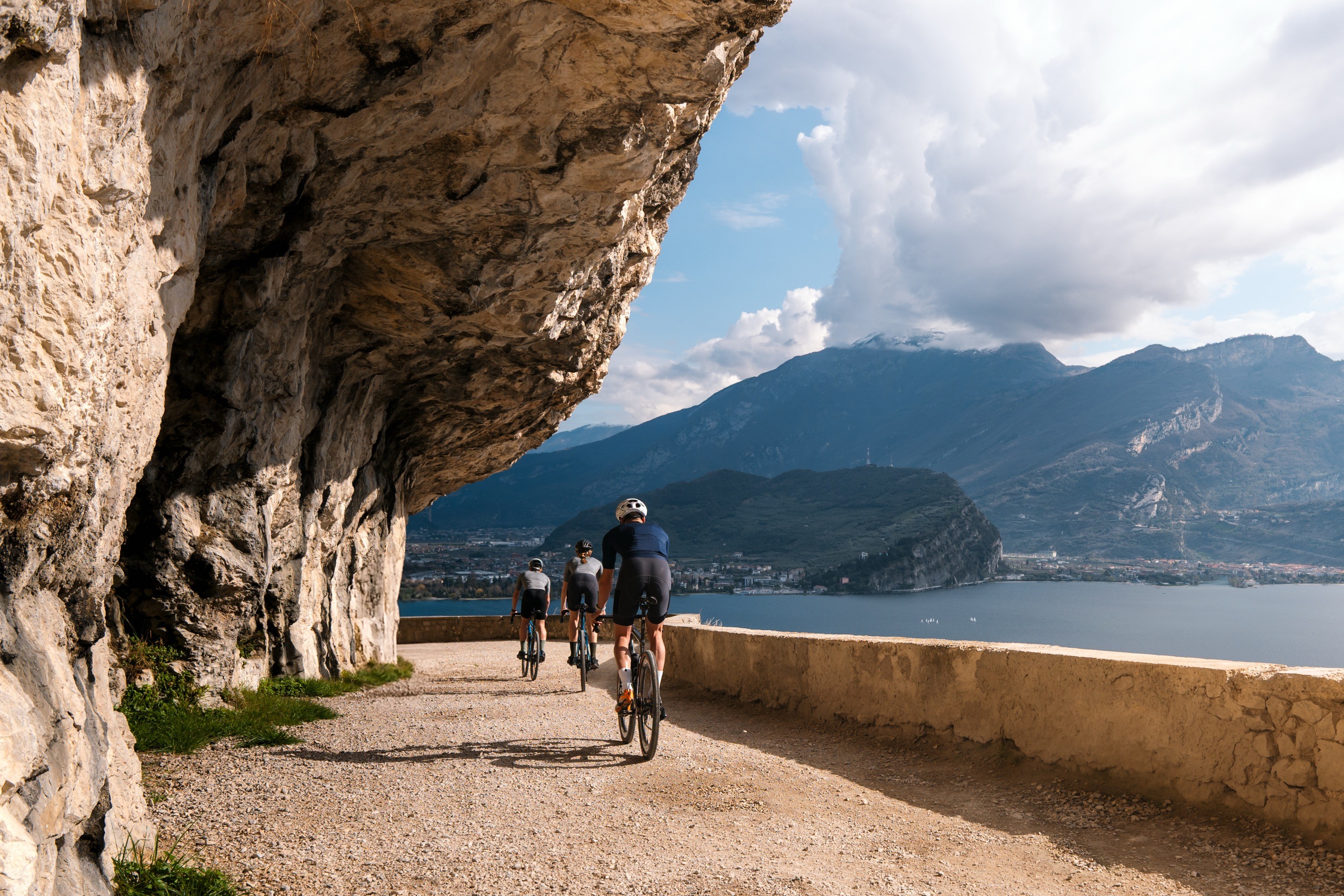 Cyclists riding the Ponale gravel road above Lake Garda.