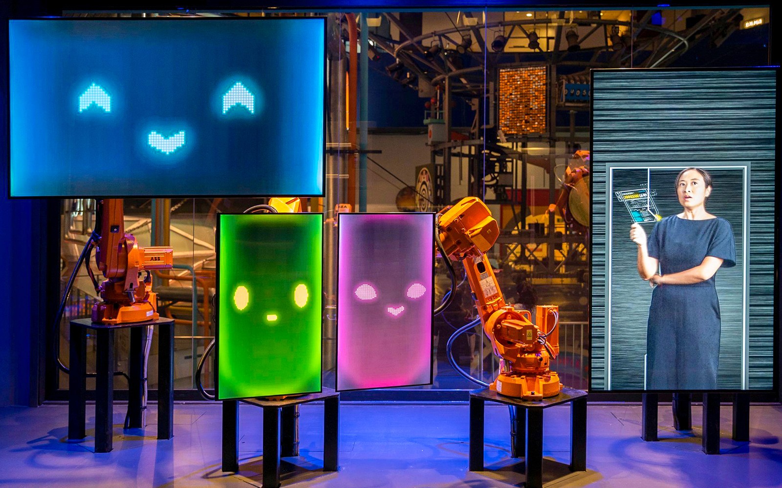 Interactive robot exhibit at Science Centre Singapore with colorful digital faces and a display screen.