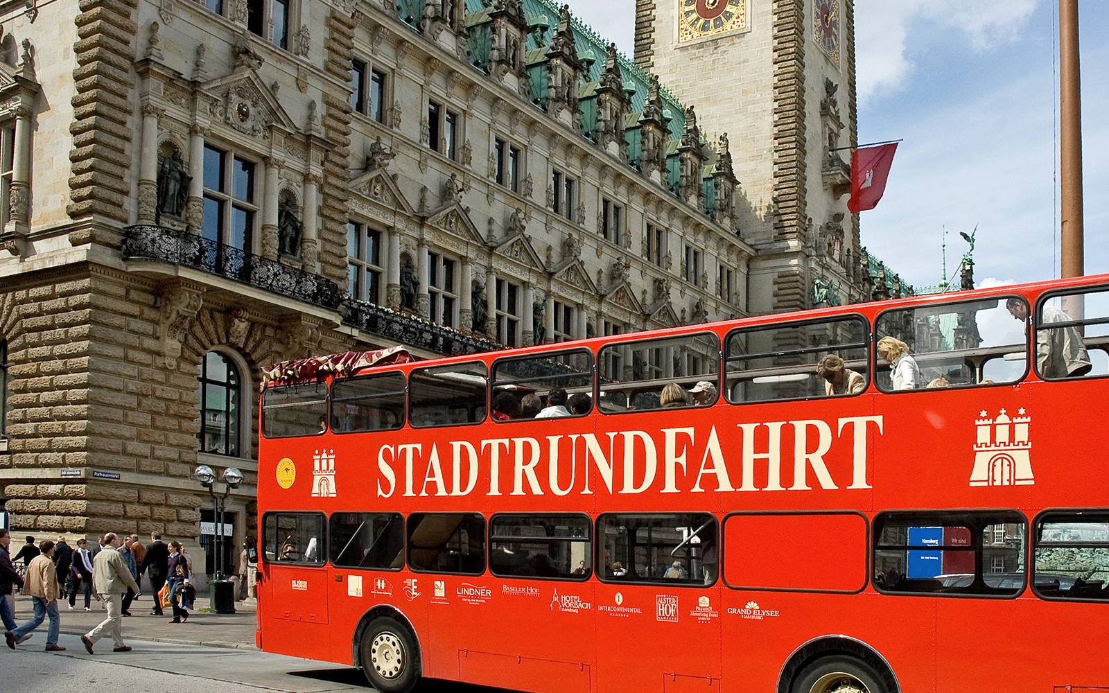 在观光旅游期间,汉堡市政厅前的红色双层巴士。