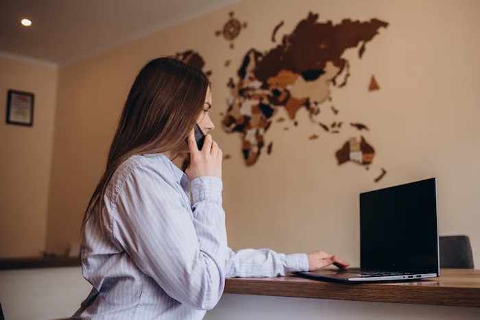 Consultora de viagens trabalhando em casa com mapa-múndi na parede