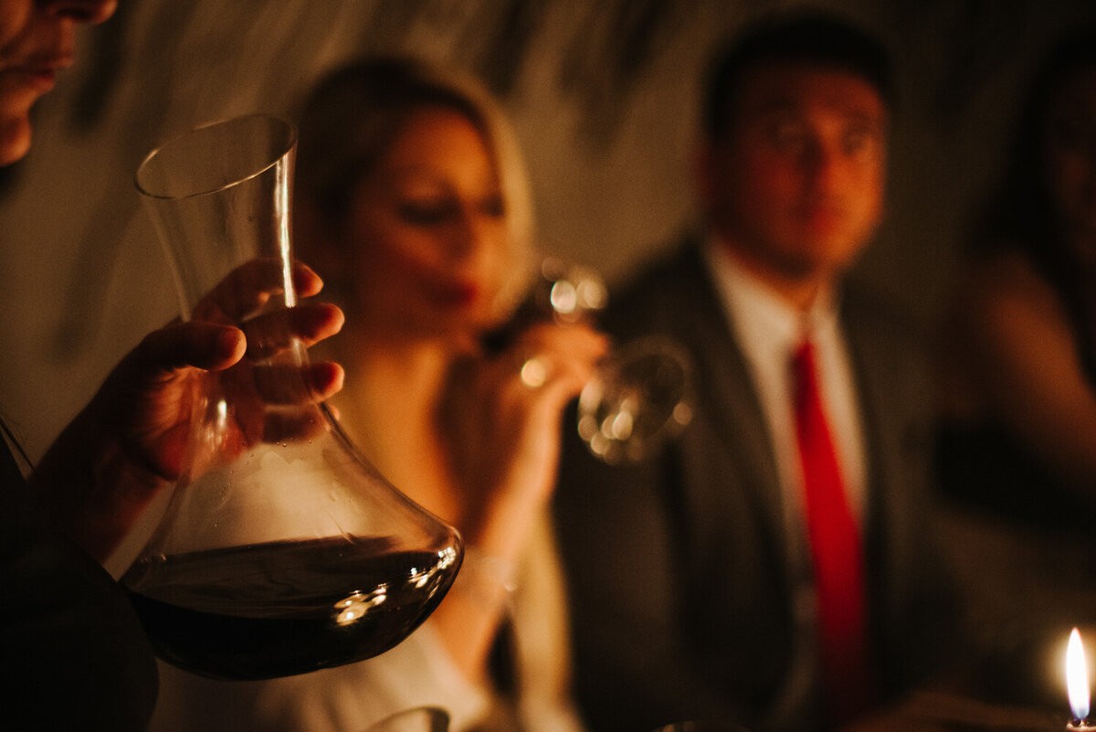 Wine service by candlelight at a Momento dinner event. The experience is built from the details of the whole evening.