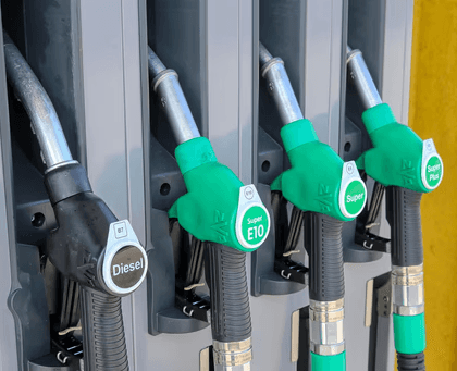 Fuel pump nozzles for diesel and gasoline, representing fuel costs and operational expenses in the trucking industry.