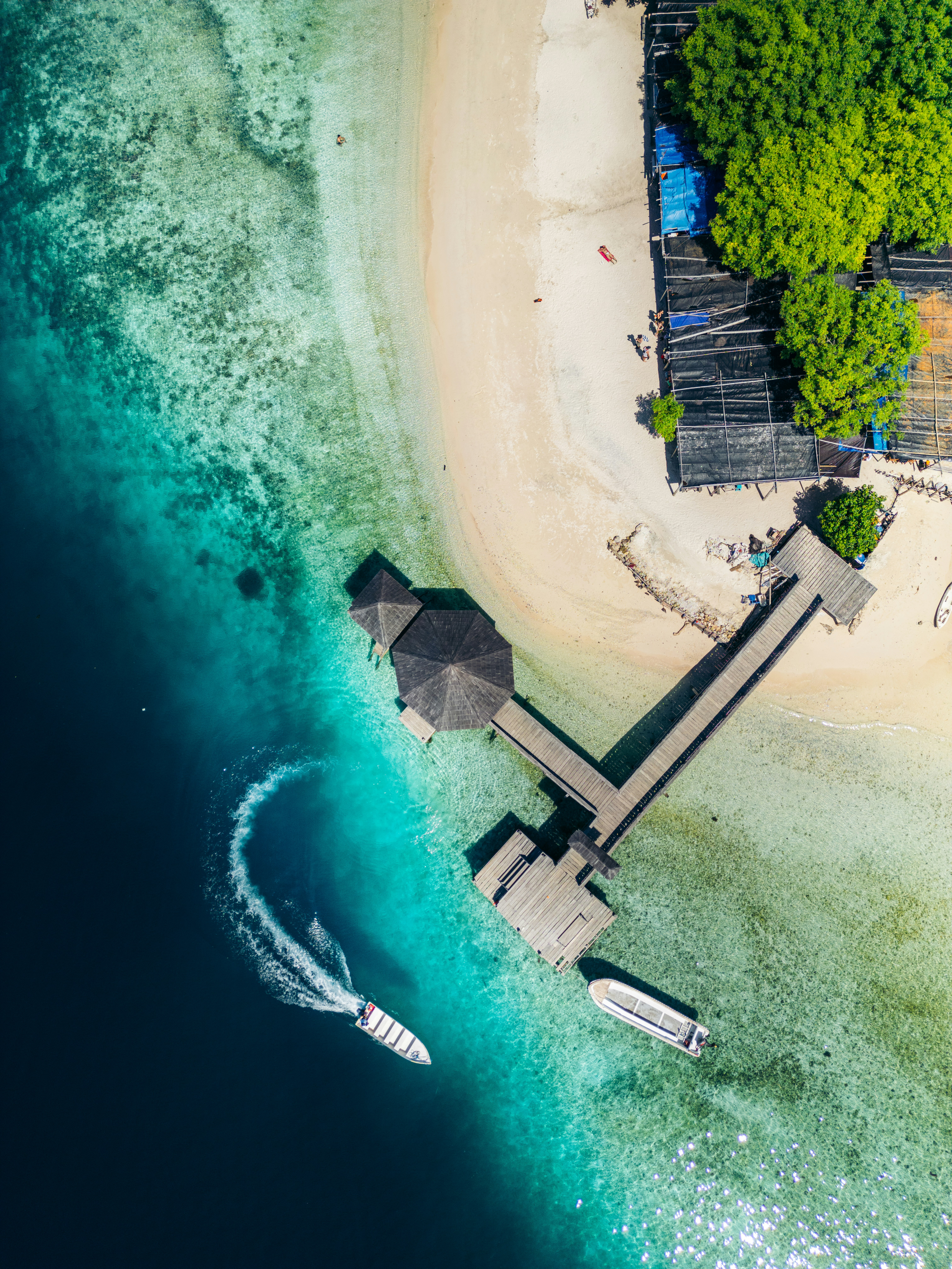 An aerial view of a beach with a boat in the water