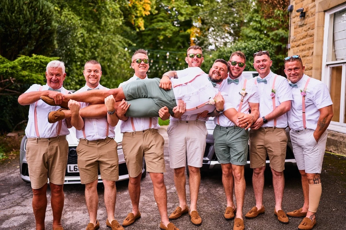 Groomsmen carrying the groom