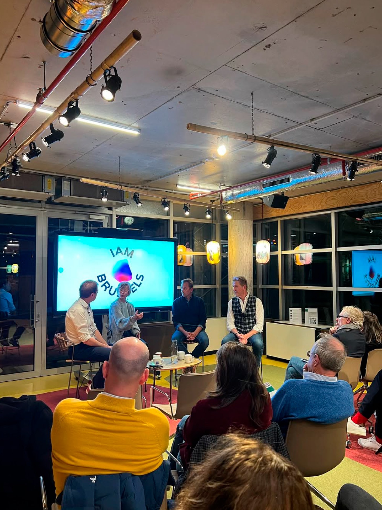 Modern home office setup with a monitor, ergonomic chair, keyboard, and indoor plants near a window with blinds.