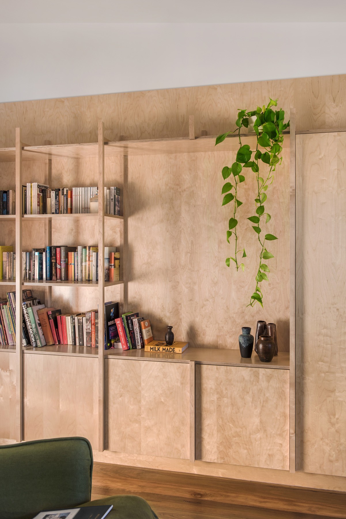 Built-in shelving and joinery detail inside Ridge House, combining timber finishes, open display, and integrated planting to soften the interior.