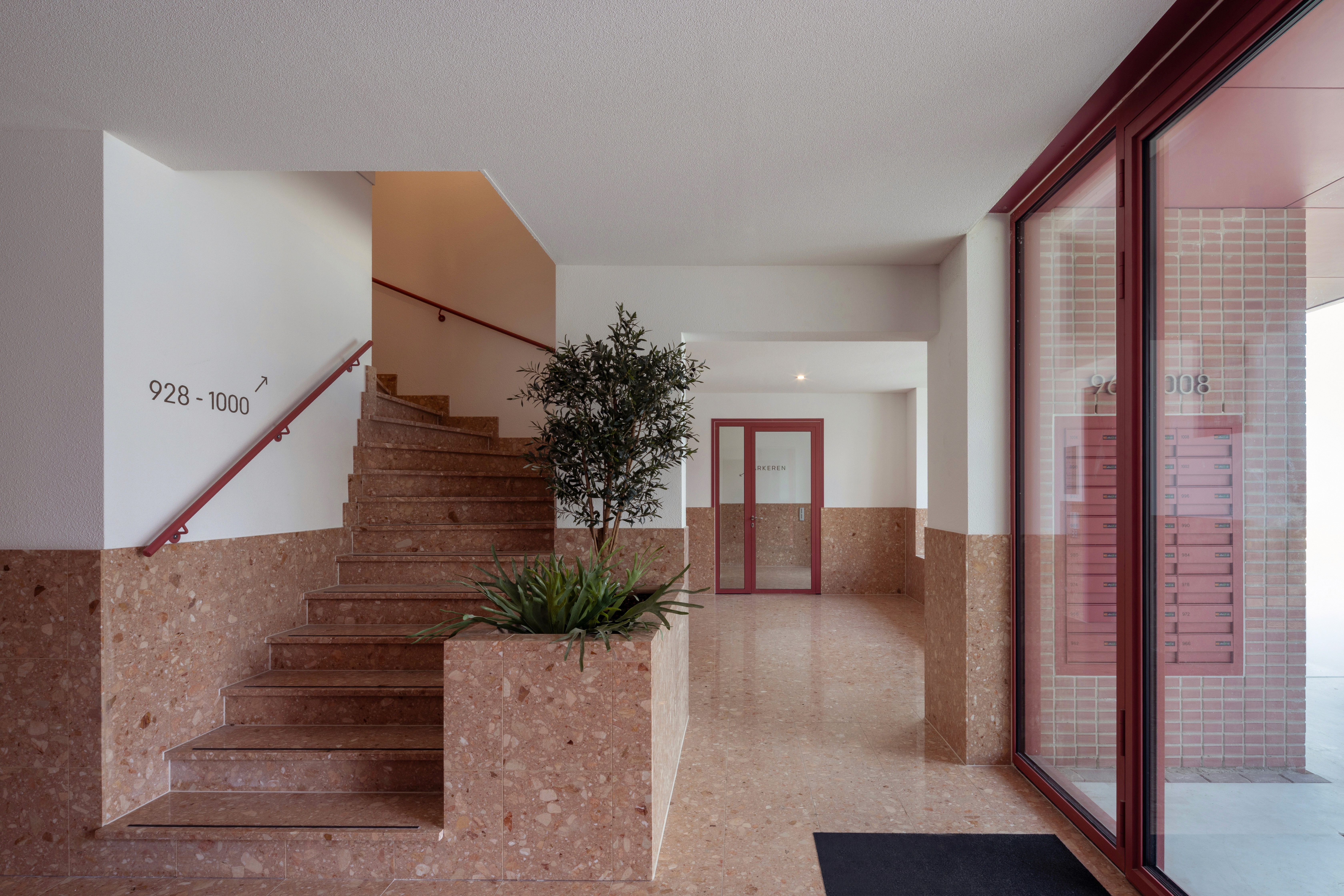 Interieur met trappenhuis,  plantenbak,  brievenbussen,  rood accent