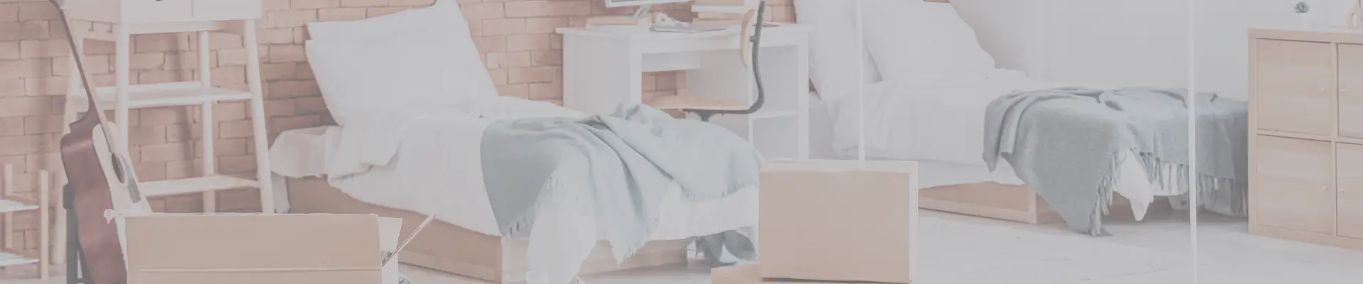 Modern dorm room with twin beds, desk, and moving boxes – what to include on your college packing list before move-in day.