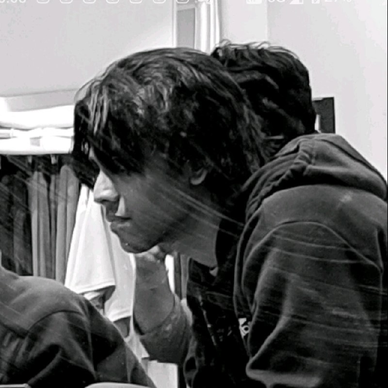 A woman examining a large architectural drawing on a table in a modern studio. Shelves and neatly arranged supplies surround her.