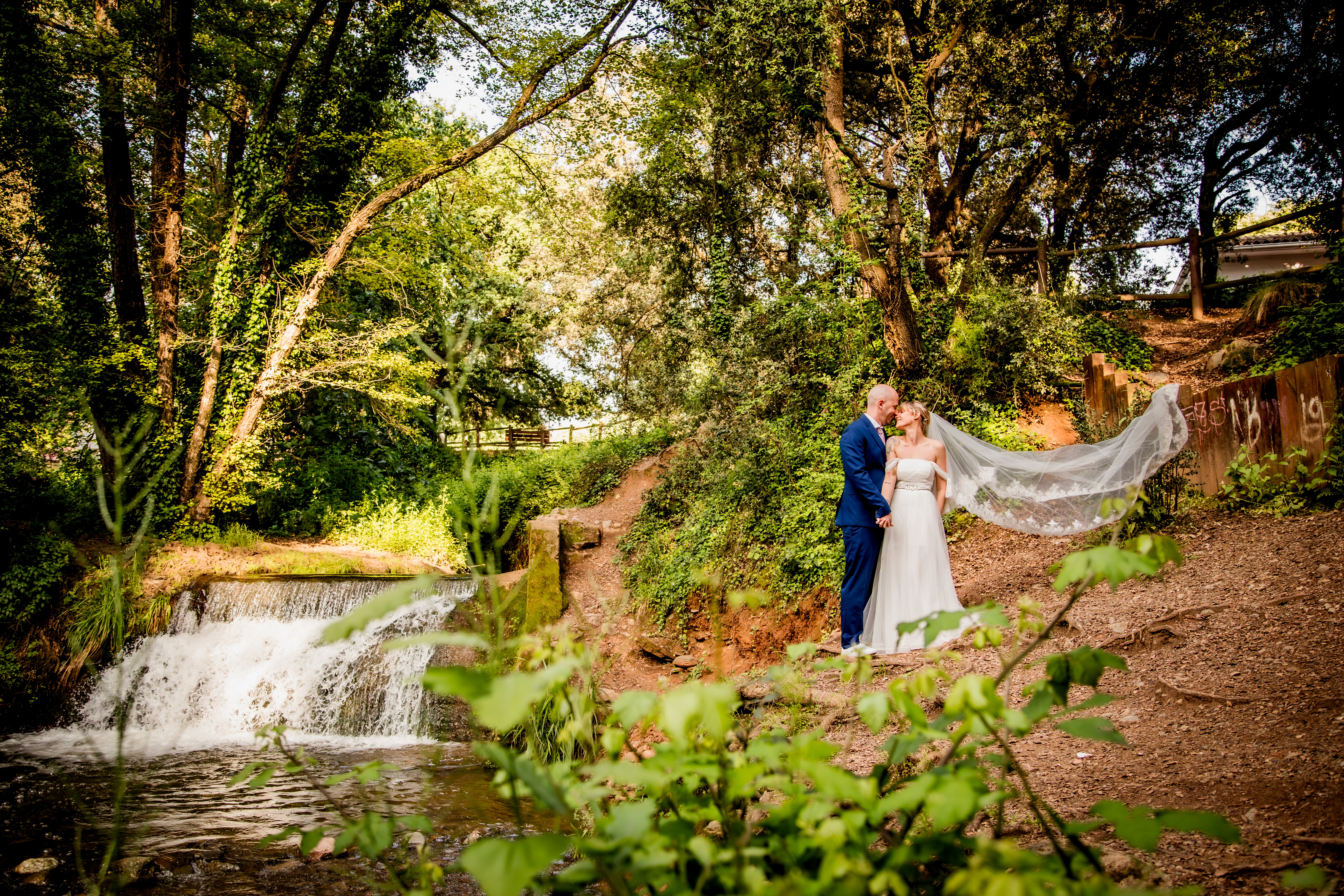 Sesión de boda donde la pareja esta situada al lado de una cascada