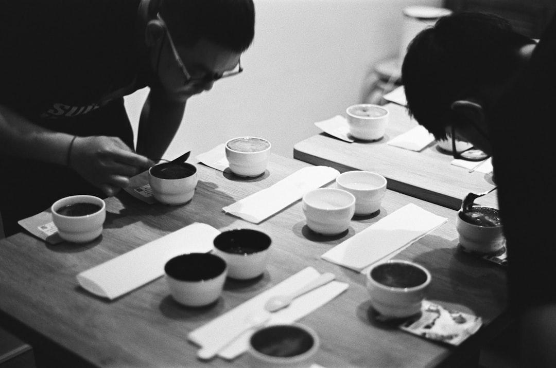 a couple of men sitting at a table with cups of coffee