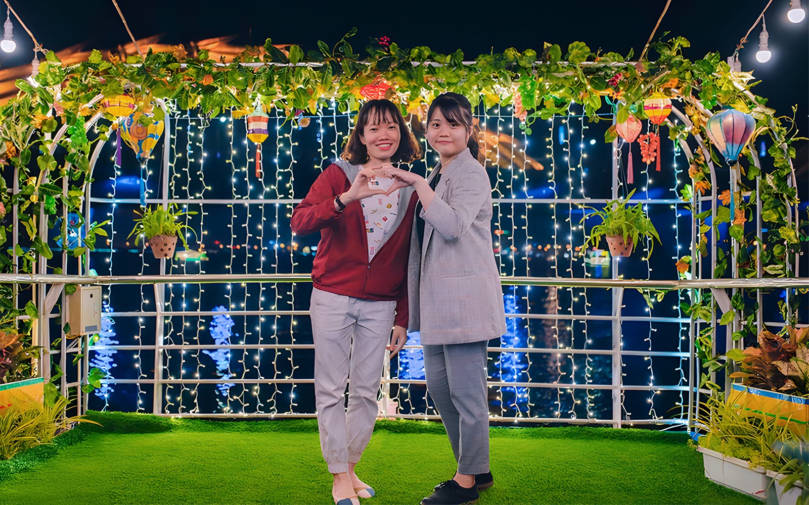 Couple on My Xuan Cruise, Han River, surrounded by lights and greenery at night.