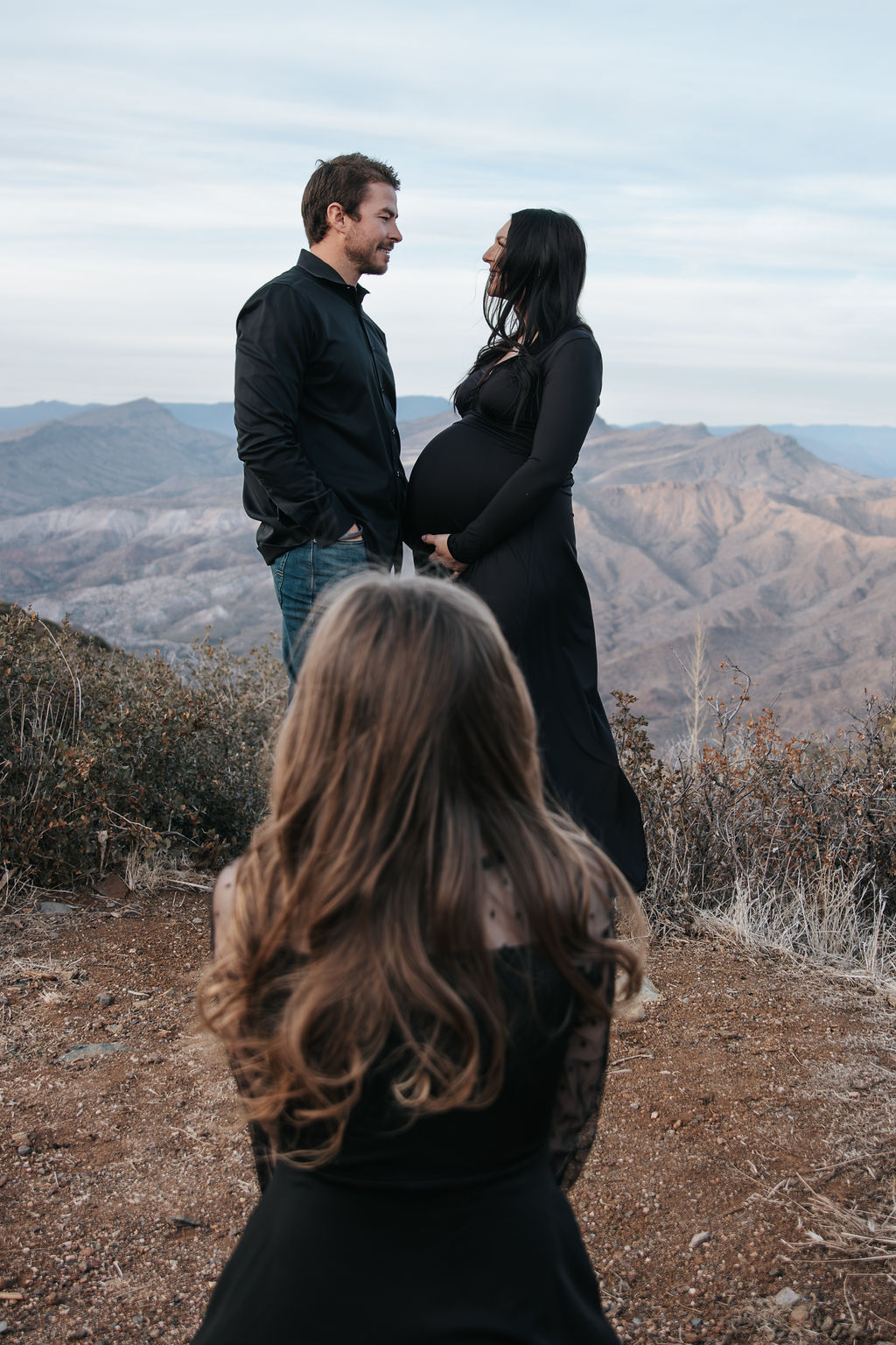 A bride and groom share a kiss surrounded by a joyful bridal party.