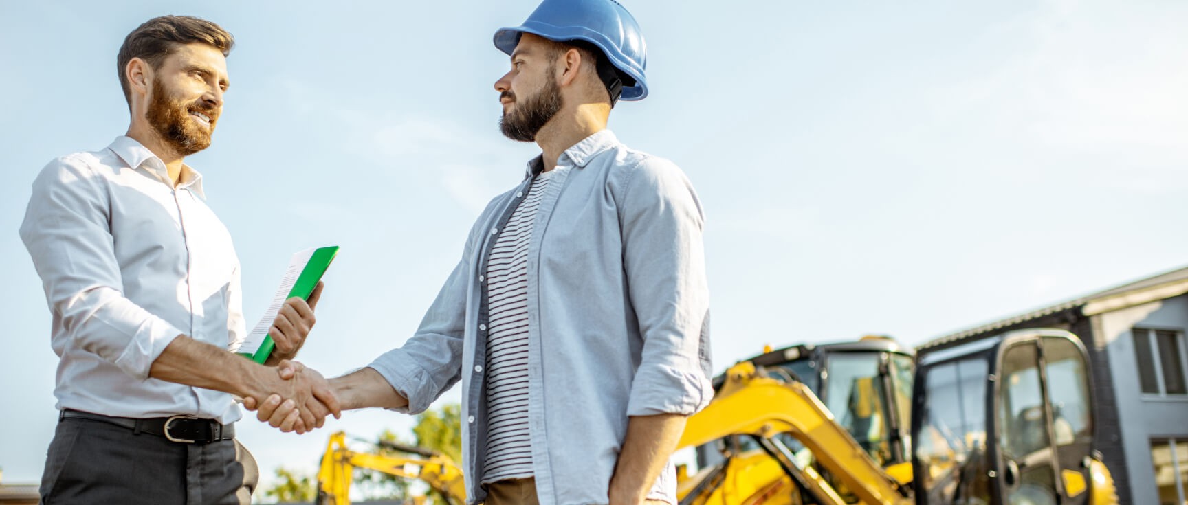 construction business owner shaking hands with a salesman for new business equipment financing