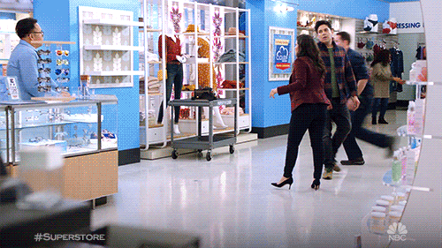 Scene from Superstore: Group of people in a store, running and looking like they are having fun.