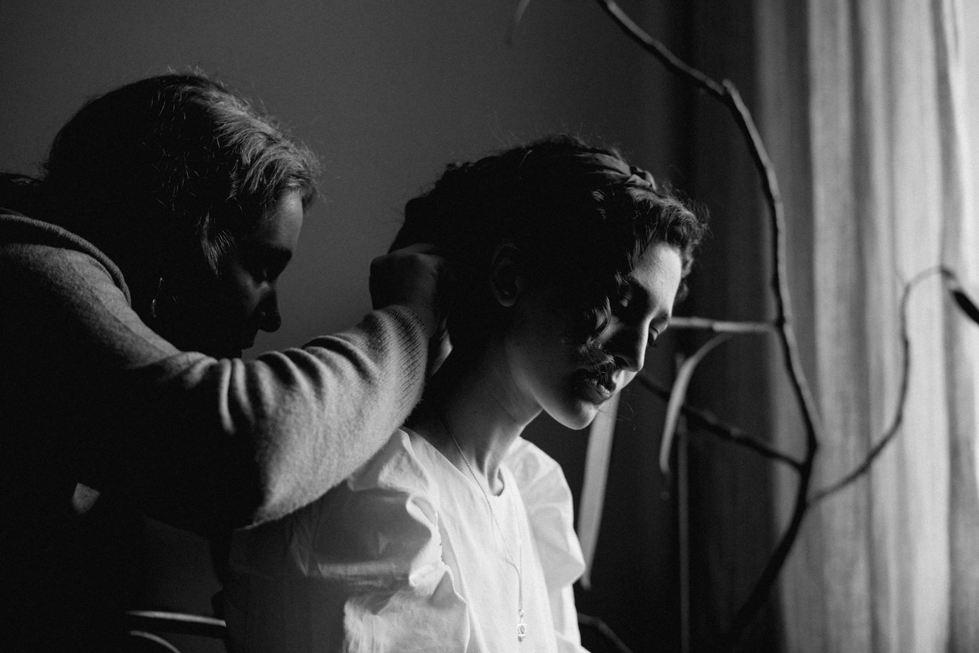 A woman receives a hairstyle makeover from another woman in a salon setting