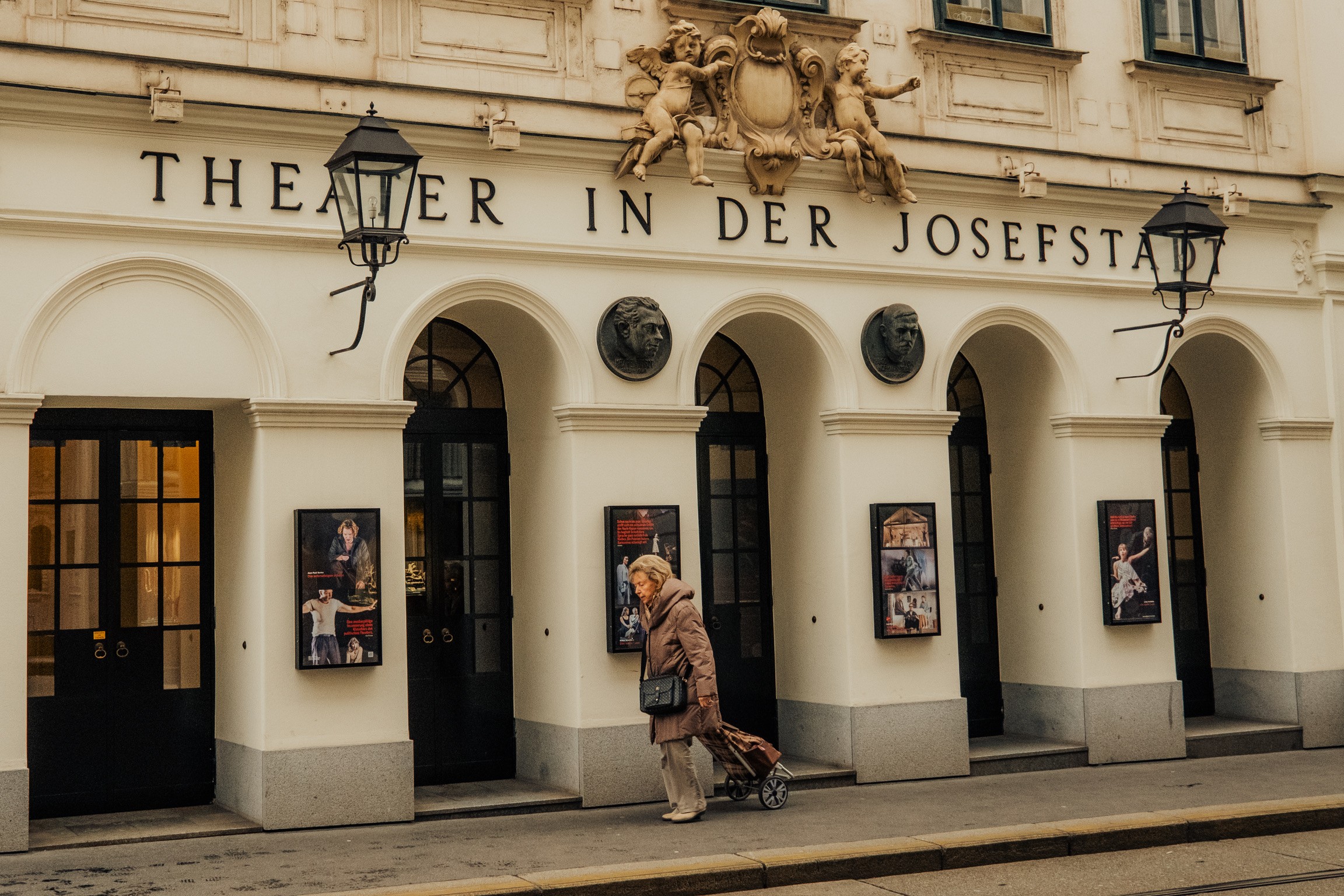 Señora con carrito pasando frente al Theater in der Josefstadt